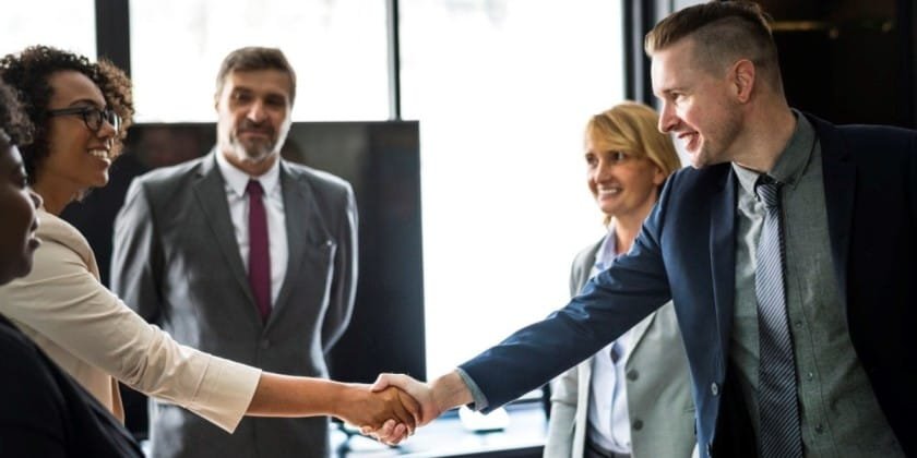 Business professionals shaking hands at a networking event.