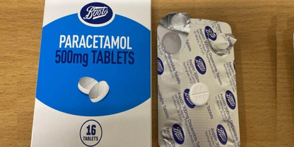 A stack of Boots own-brand paracetamol 500mg Tablets 16s, batch number 241005, sits on a pharmacy counter in London, UK, on March 4, 2025, with a warning sign highlighting a labelling error that misidentifies the painkiller as aspirin, prompting an urgent recall.