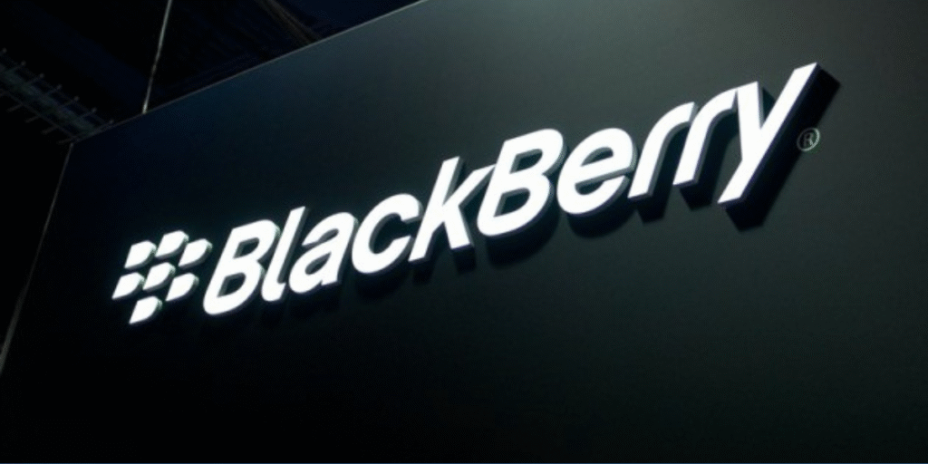 The BlackBerry logo prominently displayed on a modern glass building in Waterloo, Ontario, with a sleek digital overlay of cybersecurity code and a rising stock chart in the foreground, symbolizing the company’s 13% stock surge and strong cybersecurity revenue outlook in 2025.