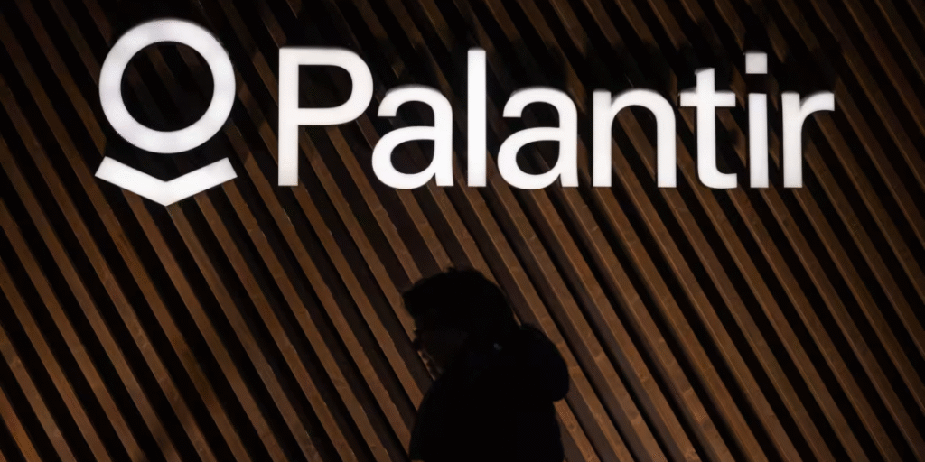 Palantir Logo outside of it's building in white and brown background and a man walking in front of it